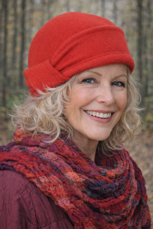 Frau trägt eine terracottafarbene Mütze bei einem Spaziergang im Wald