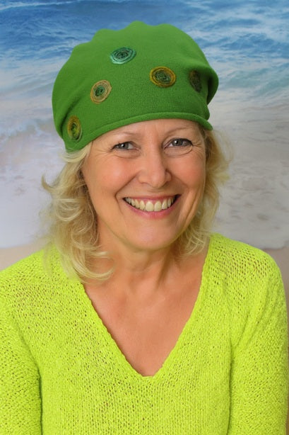 Frau trägt eine grüne Mütze und einen gelben Pullover
