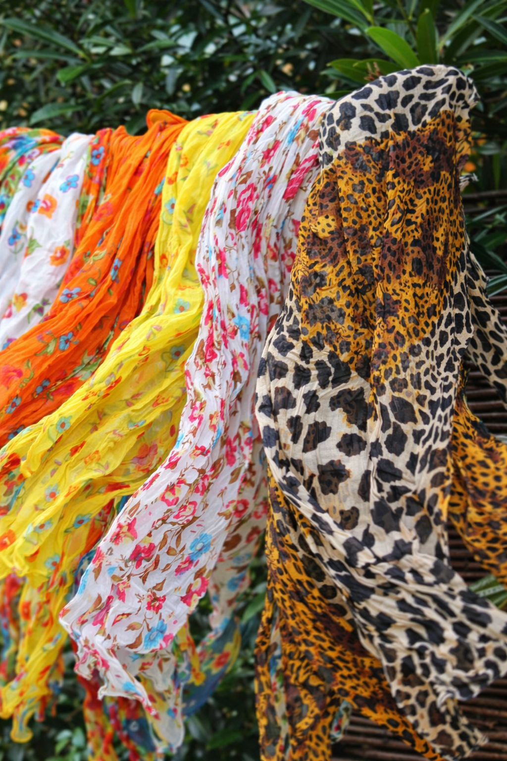 Bunte Baumwolltücher und Schals für Damen hängen im Wind im Garten