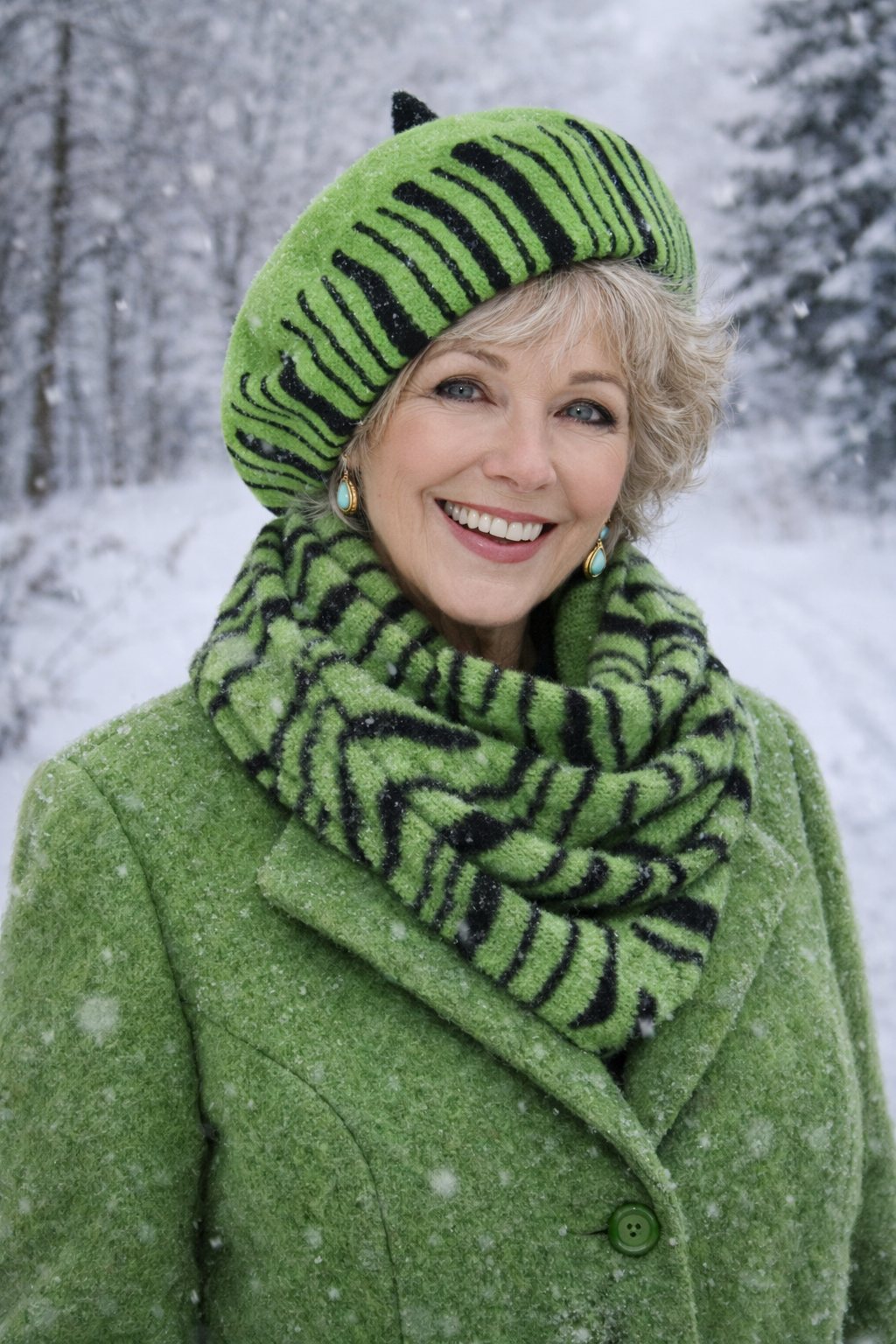 Ältere Frau steht im Wald lachend trägt eine pastellgrüne Damen Barettmütze mit passendem Schal im Winter