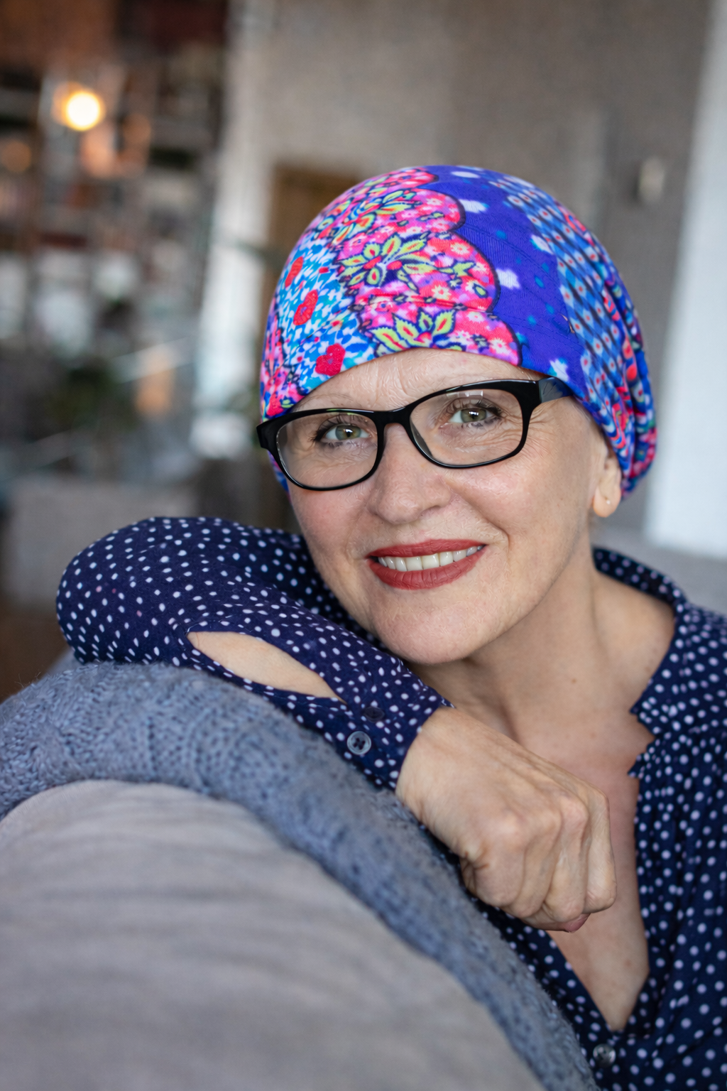 Frau trägt eine Nachtmütze mit floralem Muster als Kopfbedeckung