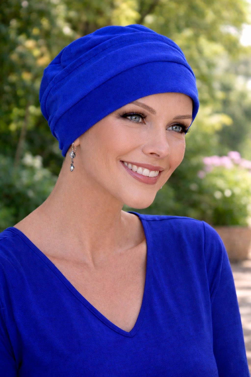 Frau im Garten mit royalblauer Chemomütze aus Baumwolle – leichte Sommer-Kopfbedeckung