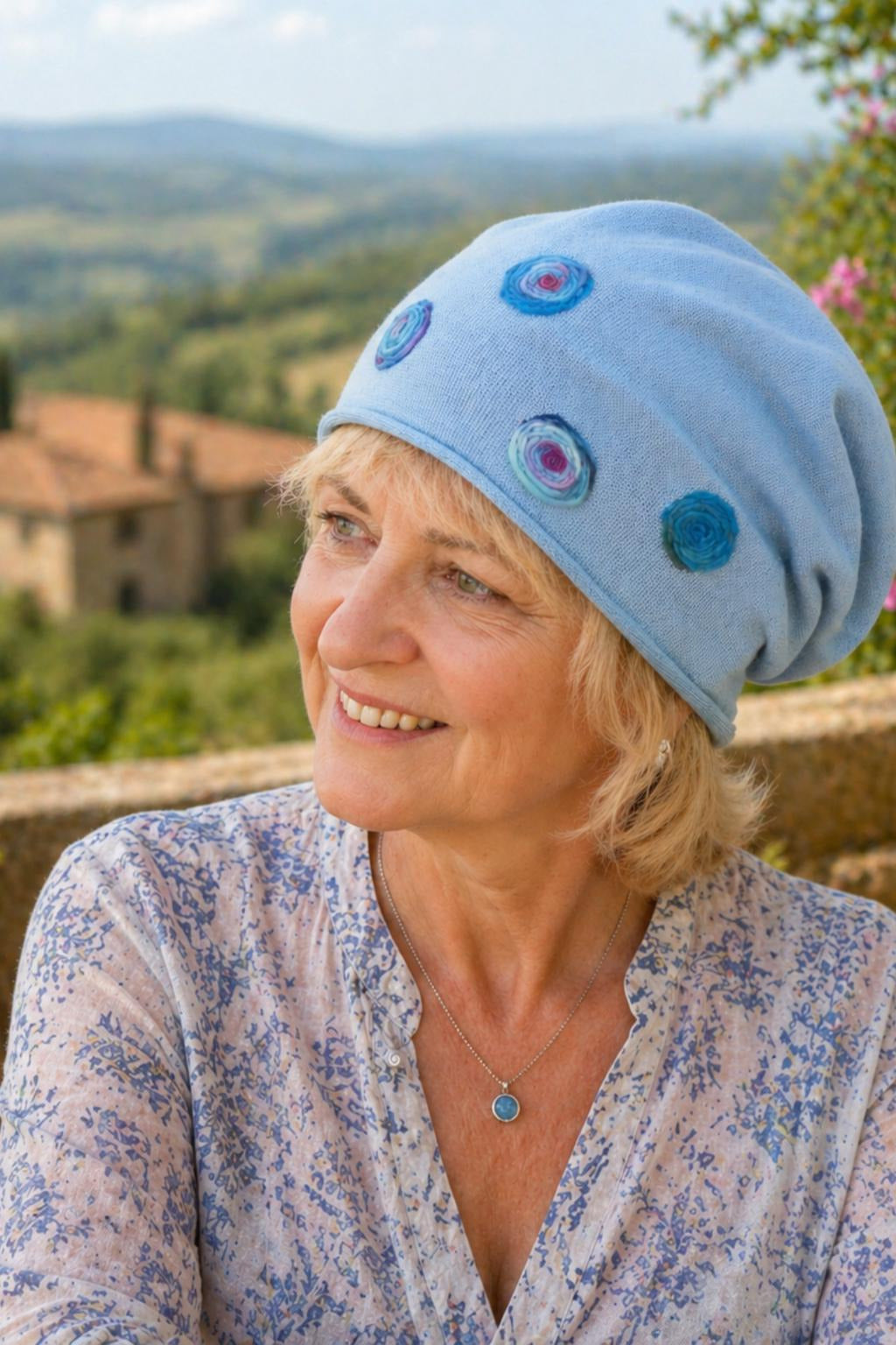 Ältere Frau trägt handmade Sommermütze aus Baumwolle und lächelt in der Toskana