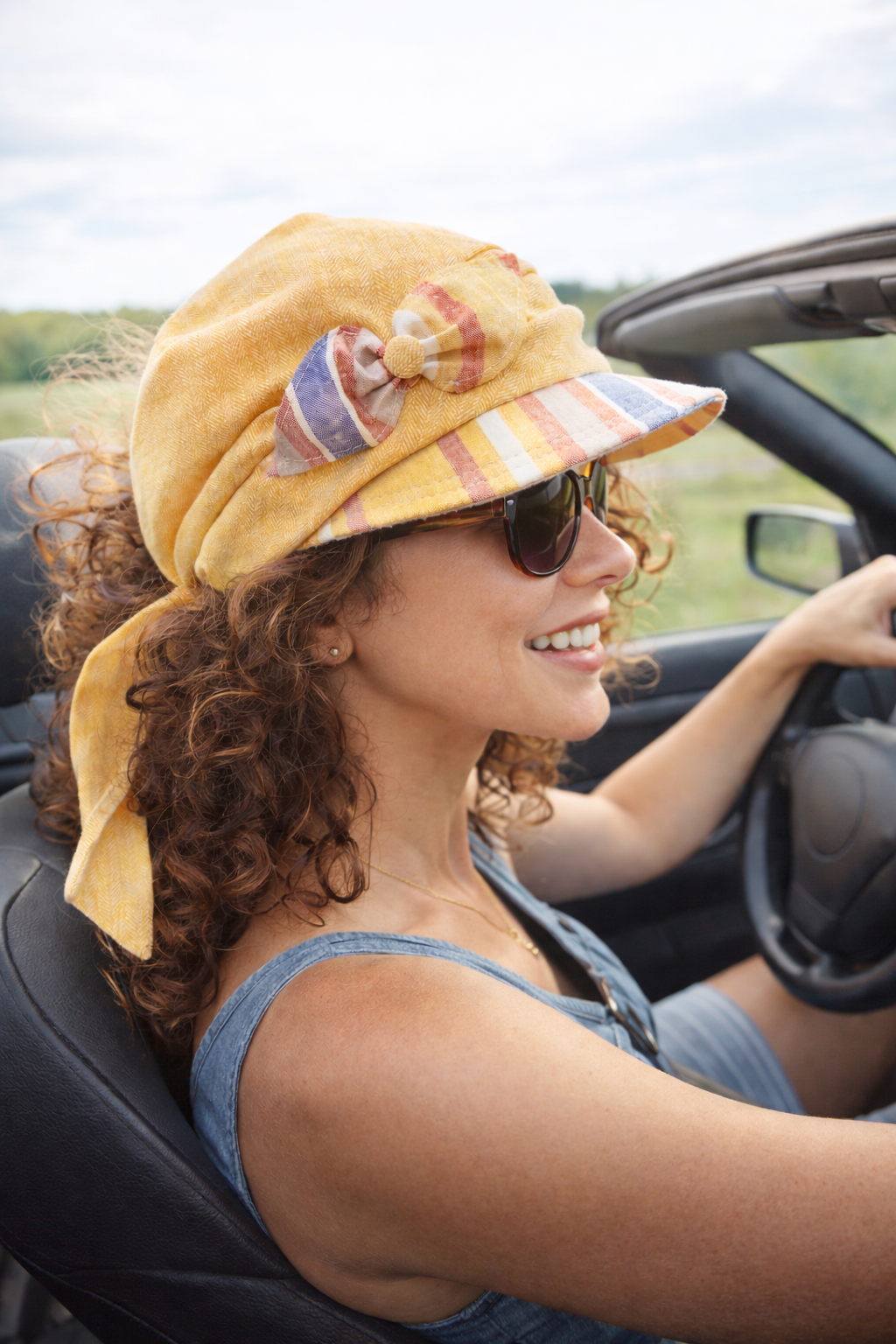 Person mit Schirmkappe auf einem Segelboot